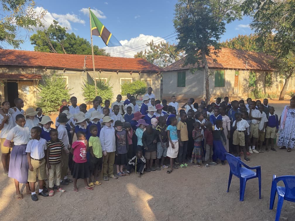 Group photo with Tanzanian flag at school outreach