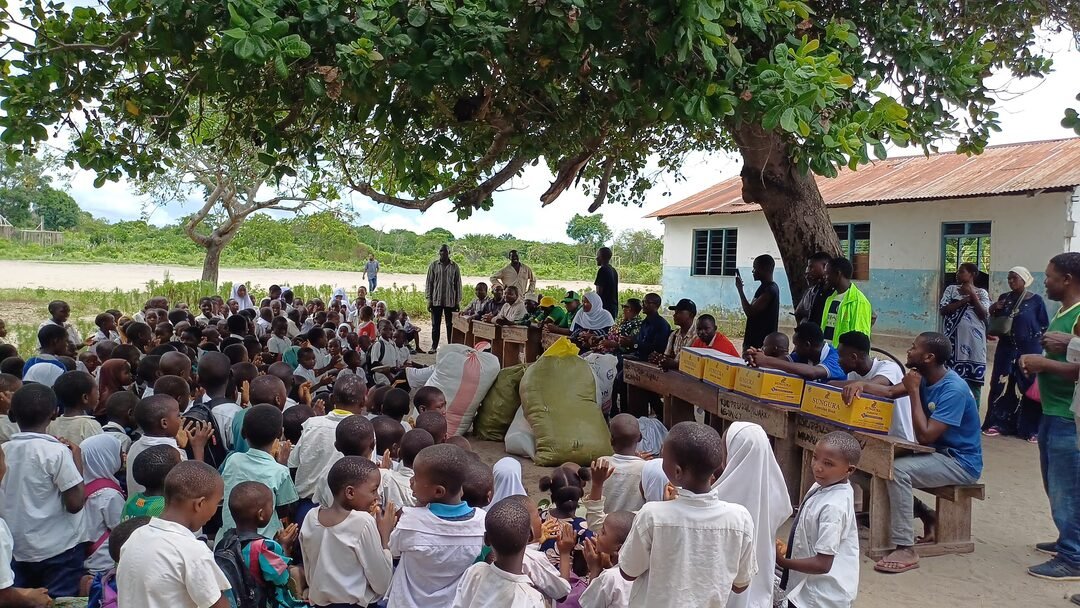 Pupils seated outdoors listening to the Foundation team